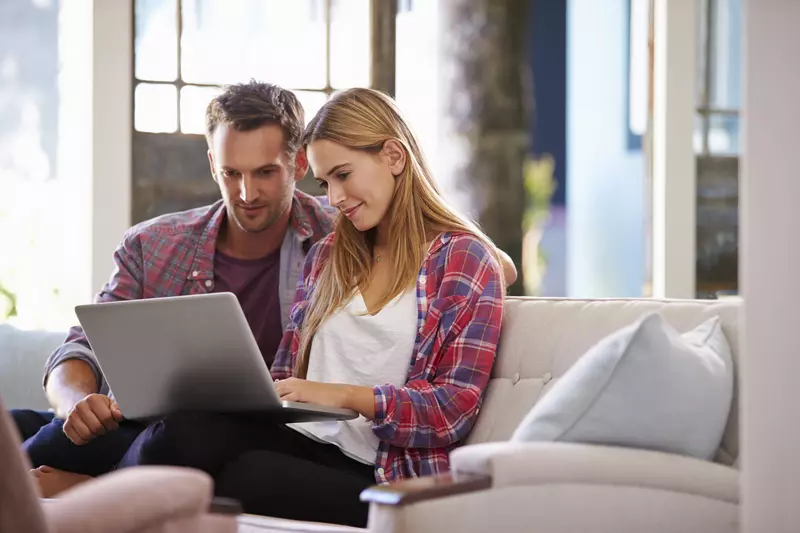 Couple booking their stay at Sidney James Mountain Lodge on laptop