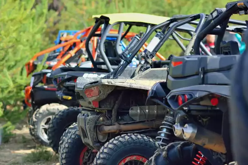 A line up of 5 ATV with greenery in the background