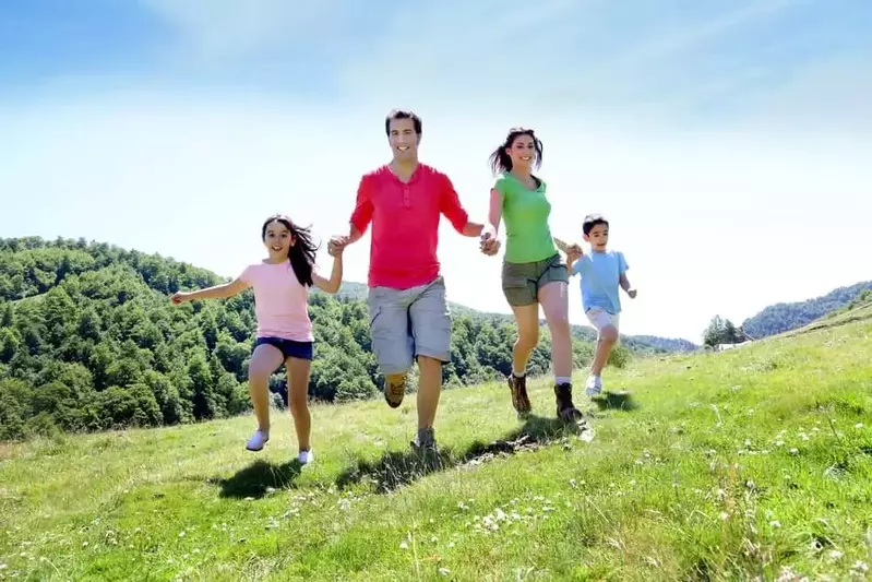 Happy family running through the mountains.