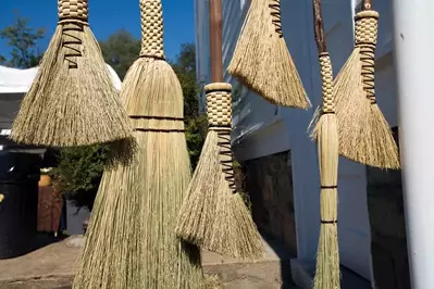 A collection of handmade brooms with designs