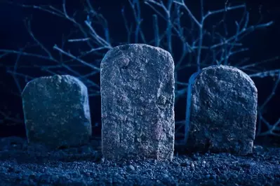 Tombstones in a graveyard at night.