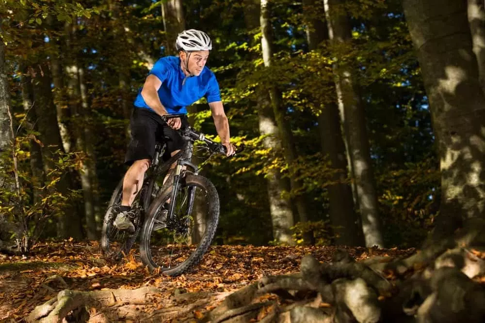 A man mountain biking in a forest.